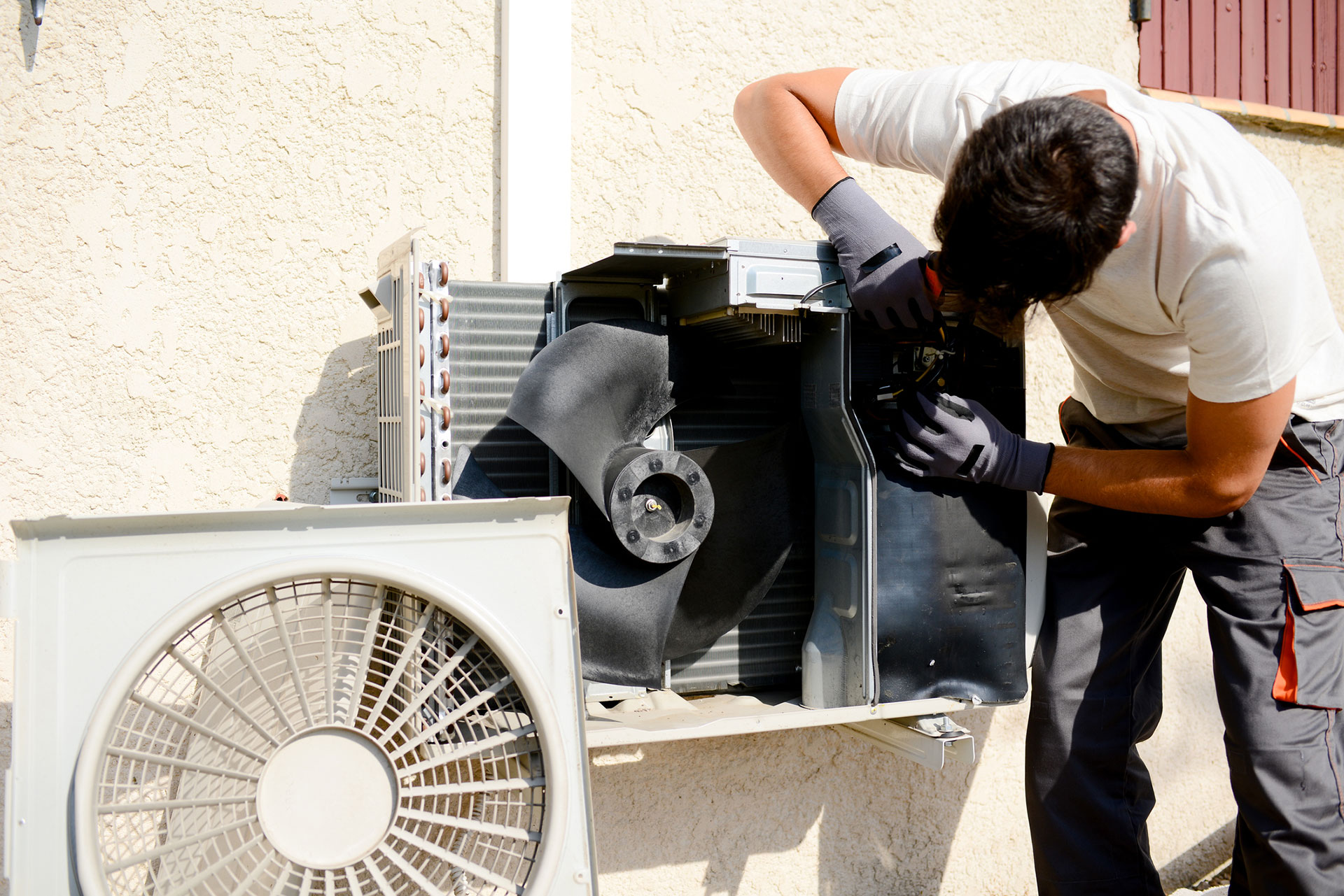 technician working on AC unit with front cover removed